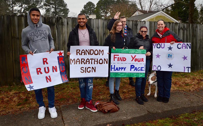 Students and staff from Denbigh High School show off their signs of encouragement for runners.
