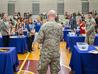 Military community members addressing a school gathering.