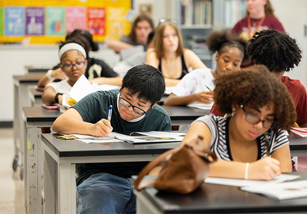 Students at their desks working in a classroom.