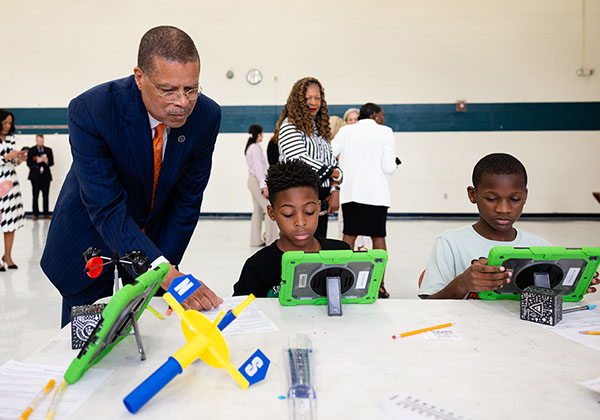 Dr. Jeffery Smith helps two fifth-grade boys with STEM tablets and building models at Newsome Park Elementary.