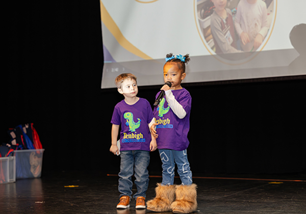 Two small preschool children on stage.