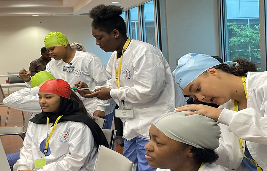Middle school students participating in the Sentara Summer Health Career Camp learned about stroke warning signs by drawing a depiction of the brain on their fellow camp mates.
